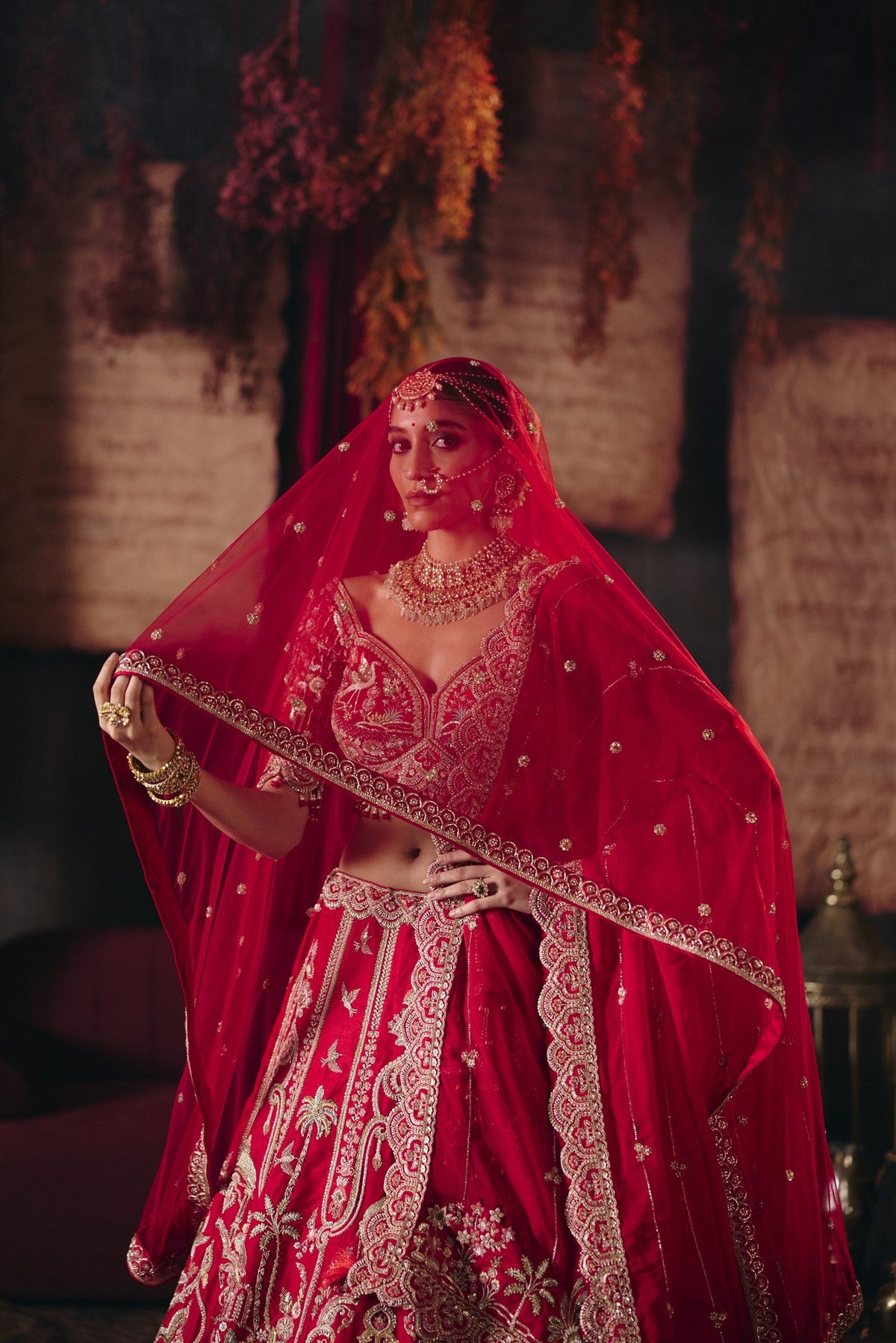 Red bird motif bridal lehenga with dupatta over the head