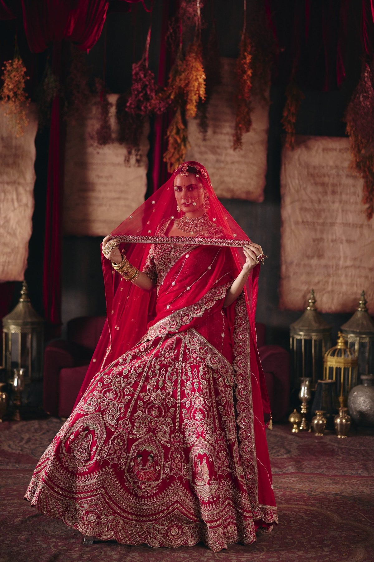 Scarlet red bridal lehenga with dupatta held overhead