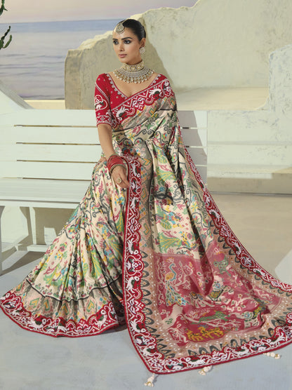 Cream patola saree, pallu spread on steps