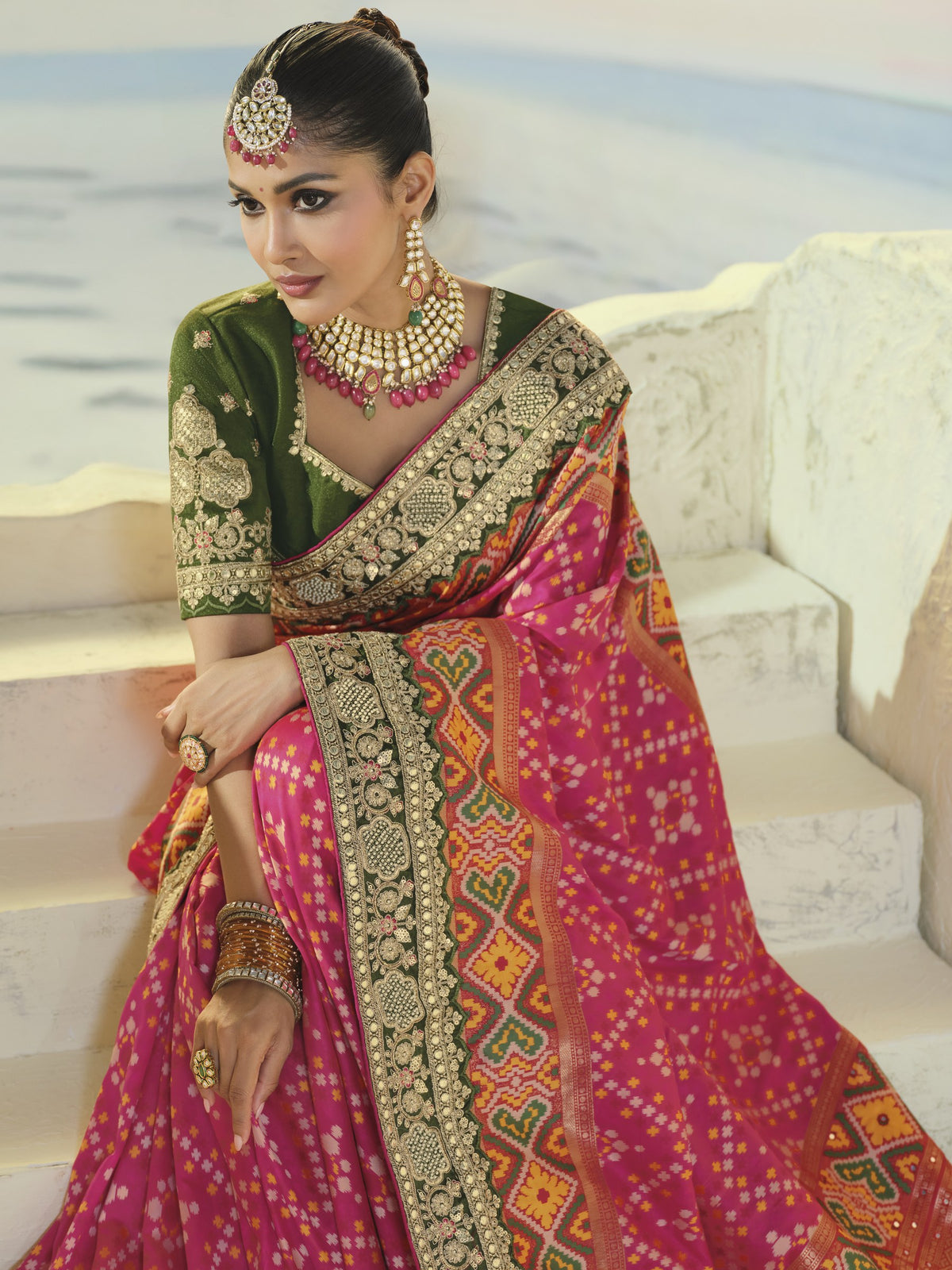 Rani pink patola saree, green embroidered border close-up