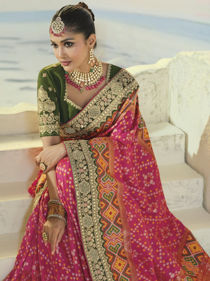 Rani pink patola saree, green embroidered border close-up