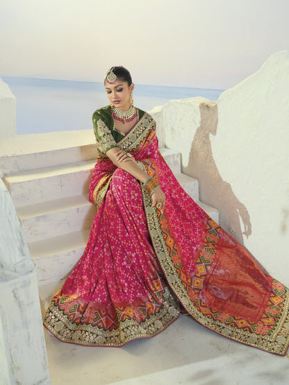 Rani pink patola saree, seated view with pallu